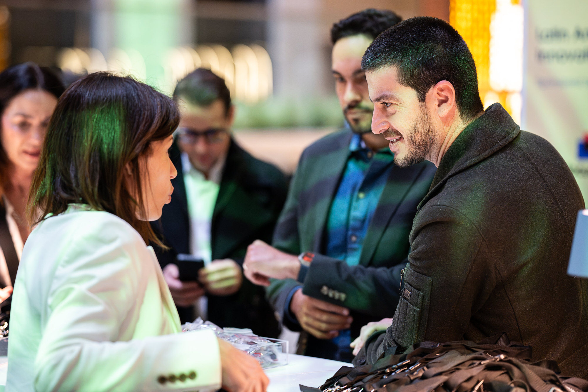 Attendees gathered around a sponsor table at a brand activation