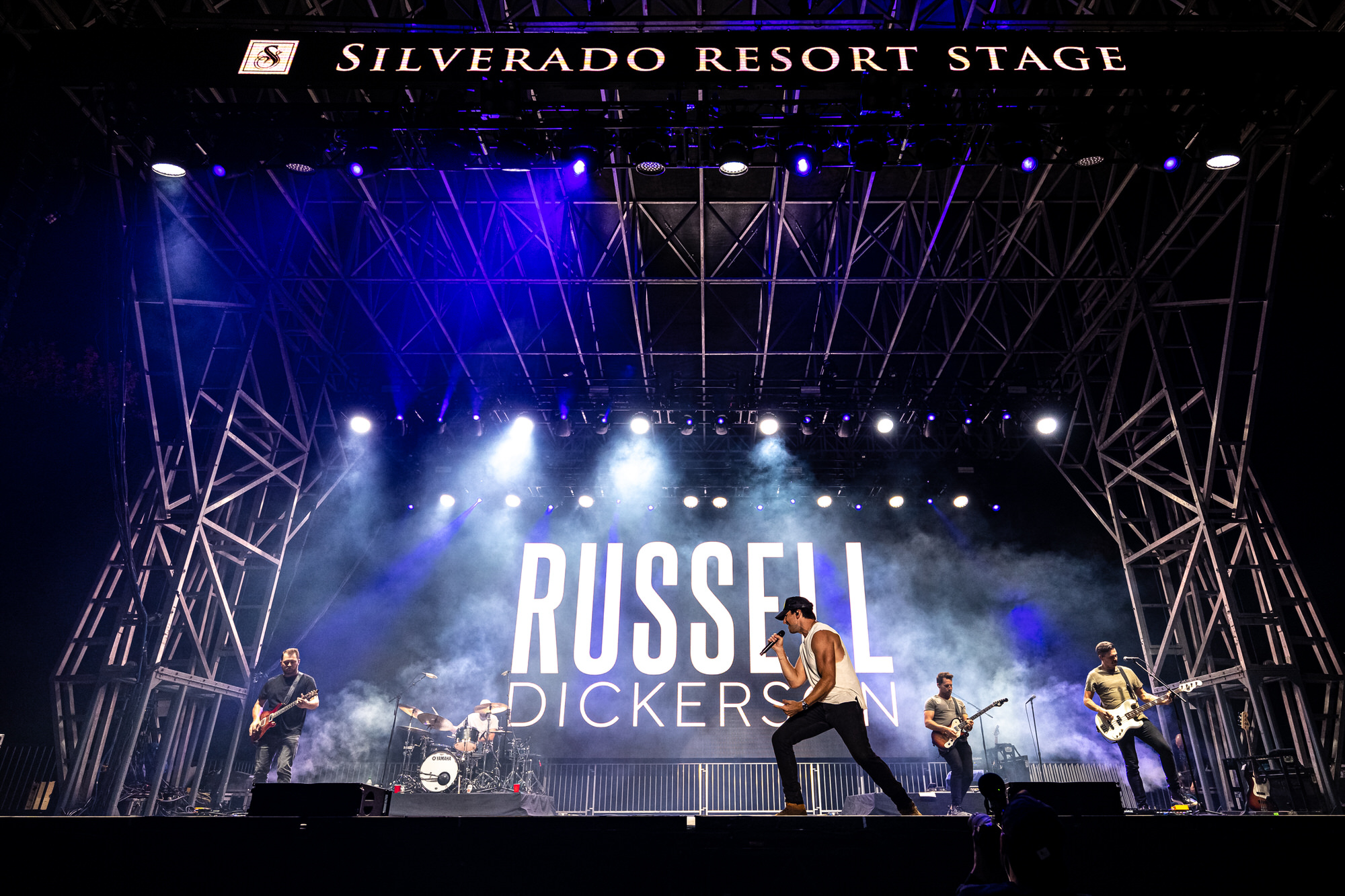 Wide view of the headline act performing under blue stage lights