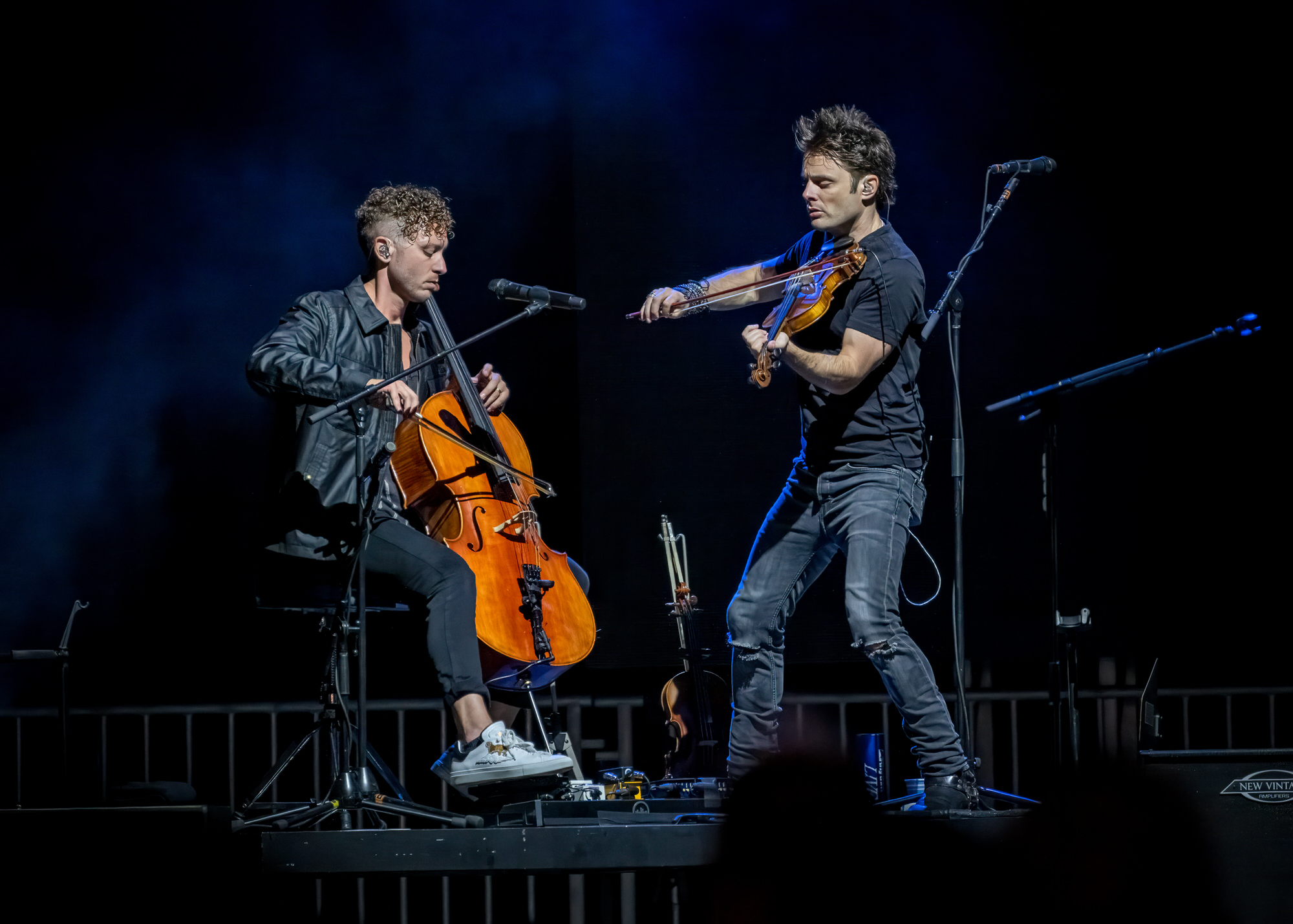 Cellist and violinist performing on stage