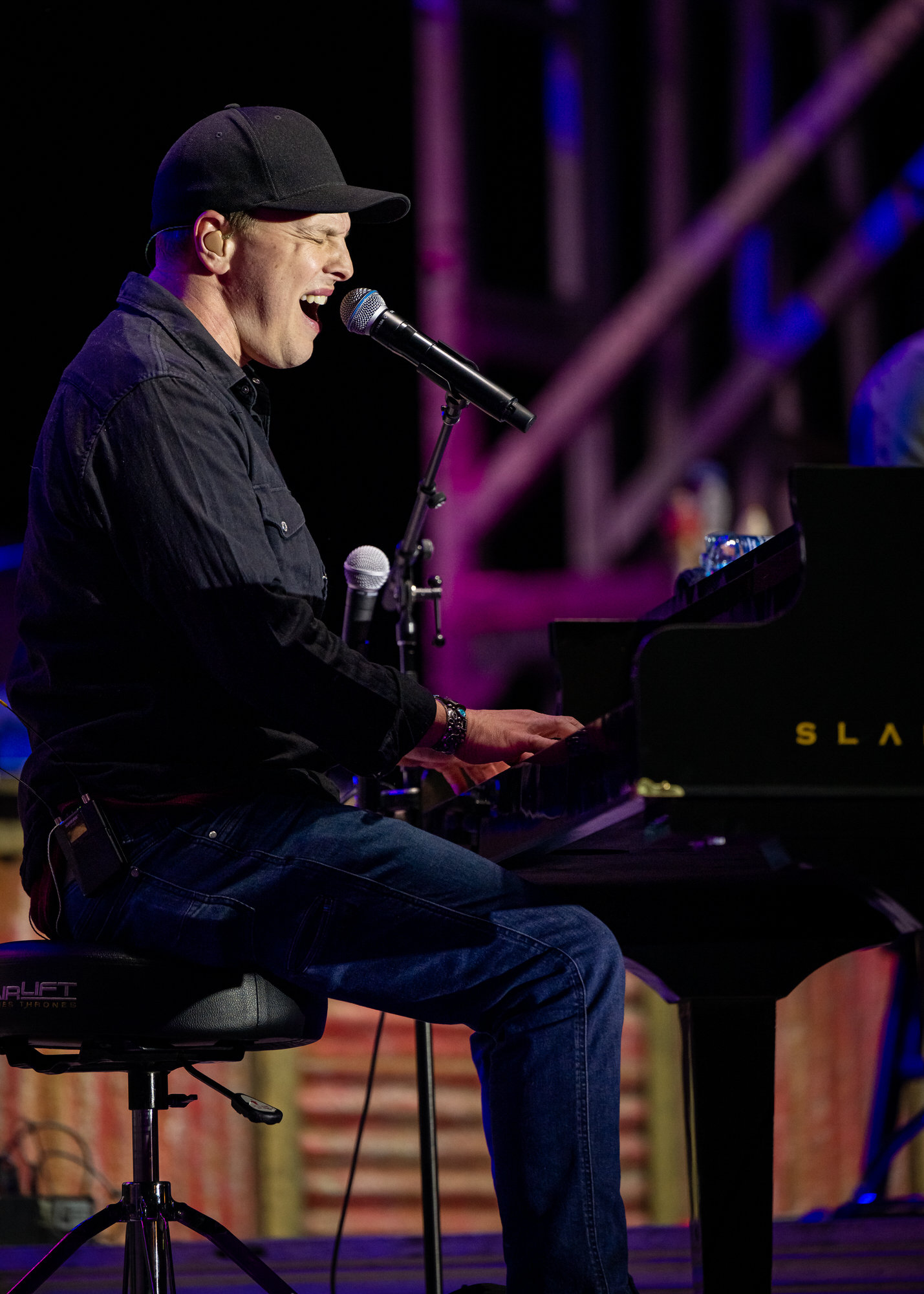 Singer playing a grand piano on stage