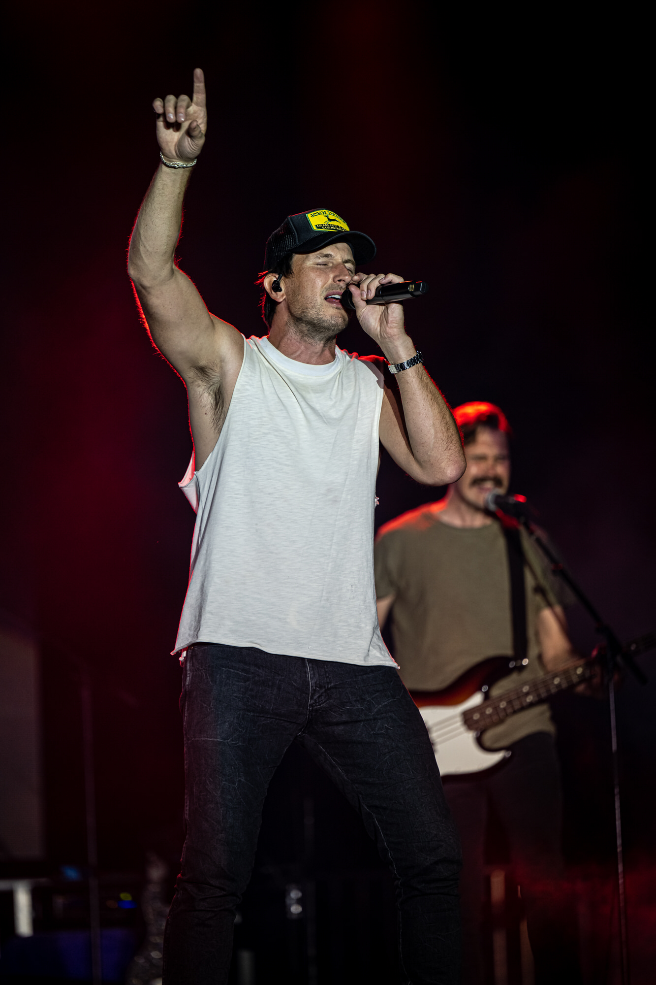 Singer pointing skyward during a song, guitarist behind him