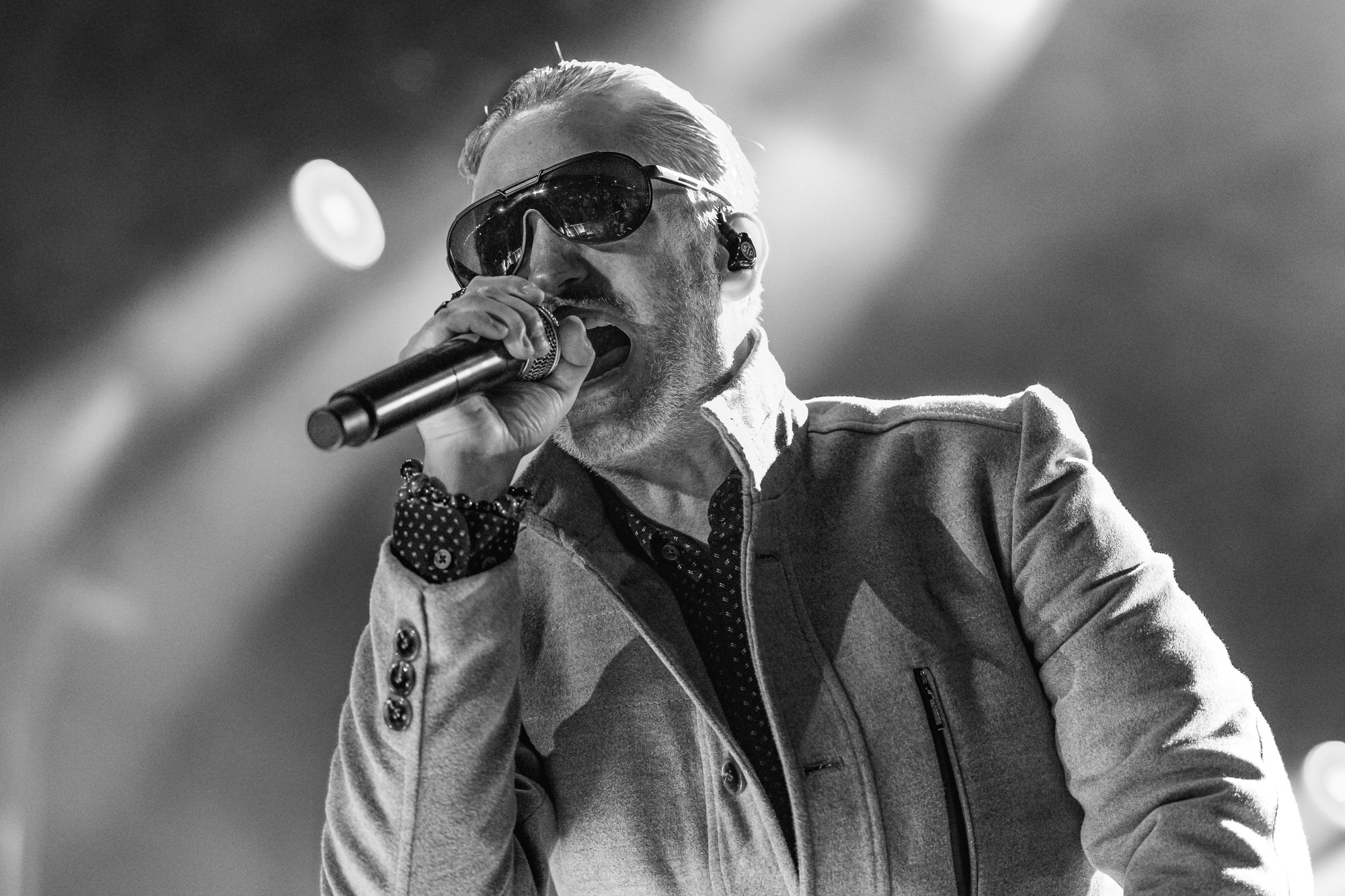 Black-and-white photo of a singer in sunglasses and a blazer