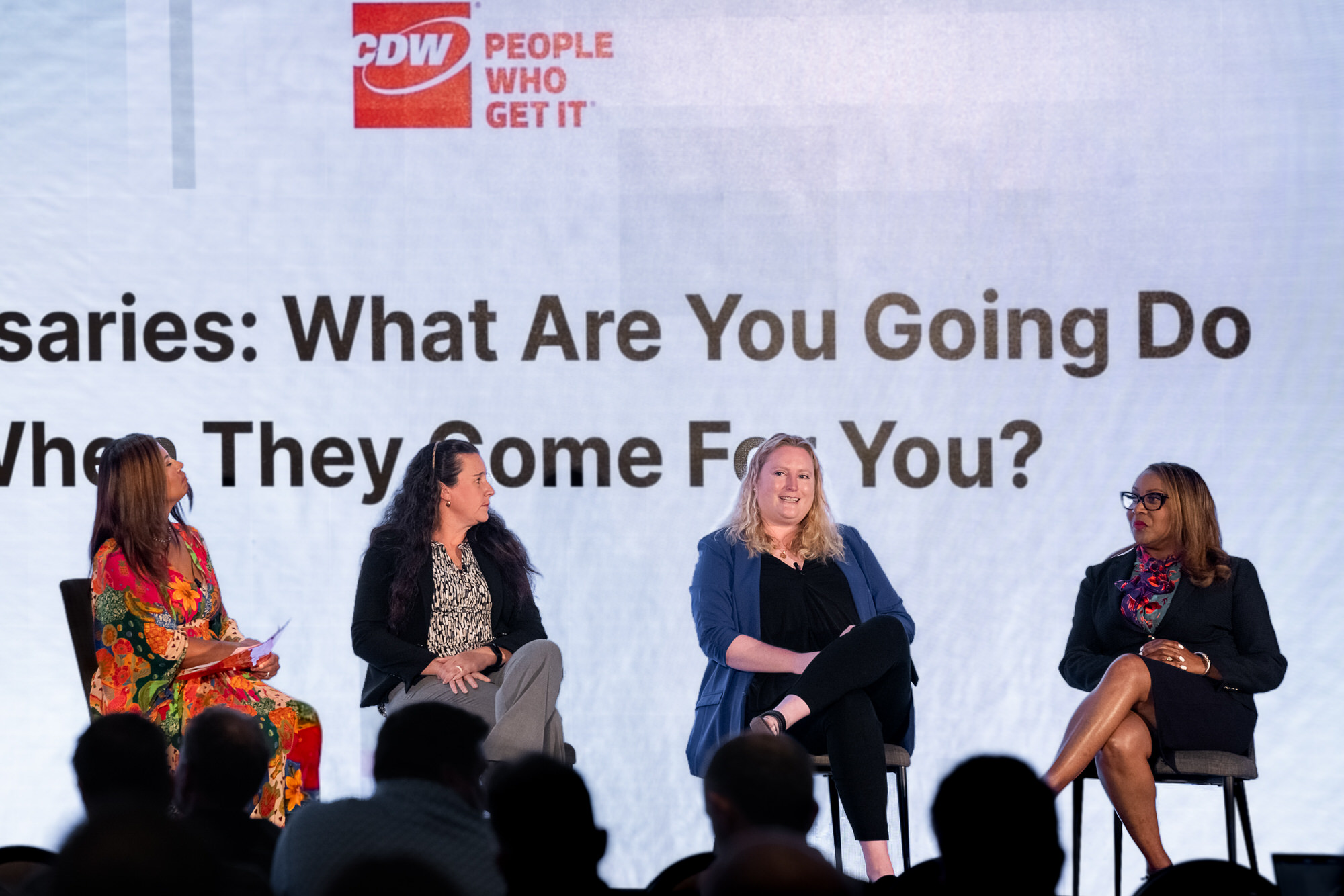 Four panelists seated on stage during a panel discussion