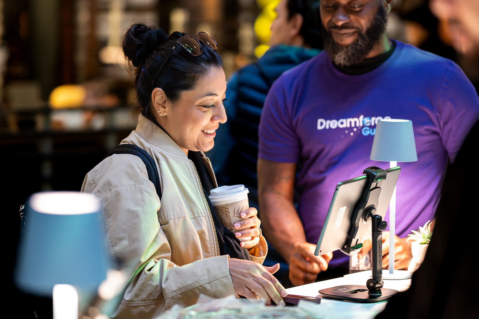 Staff member helping an attendee sign in at a registration kiosk