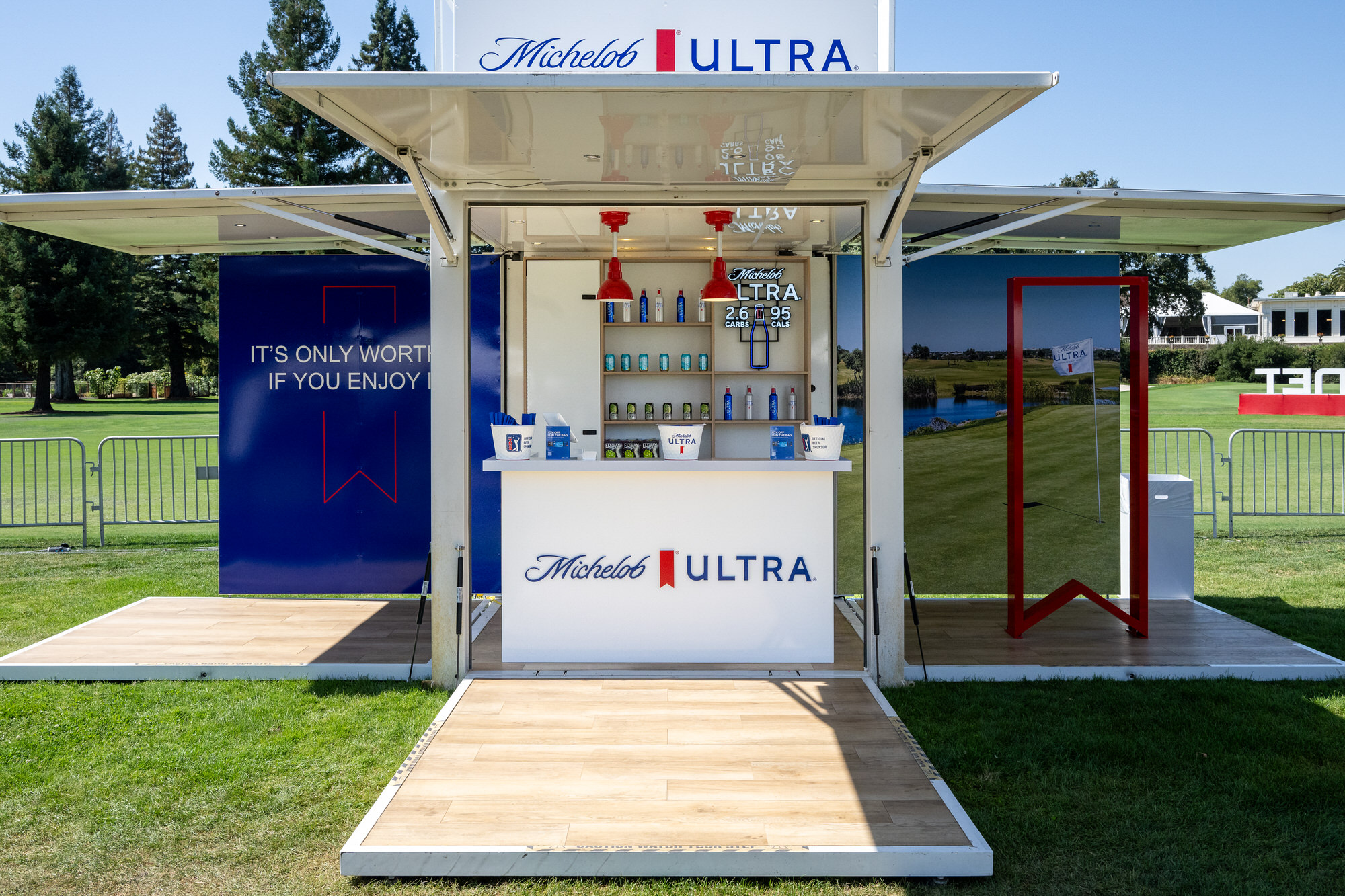 Sponsor bar kiosk set up on the lawn beside a golf course