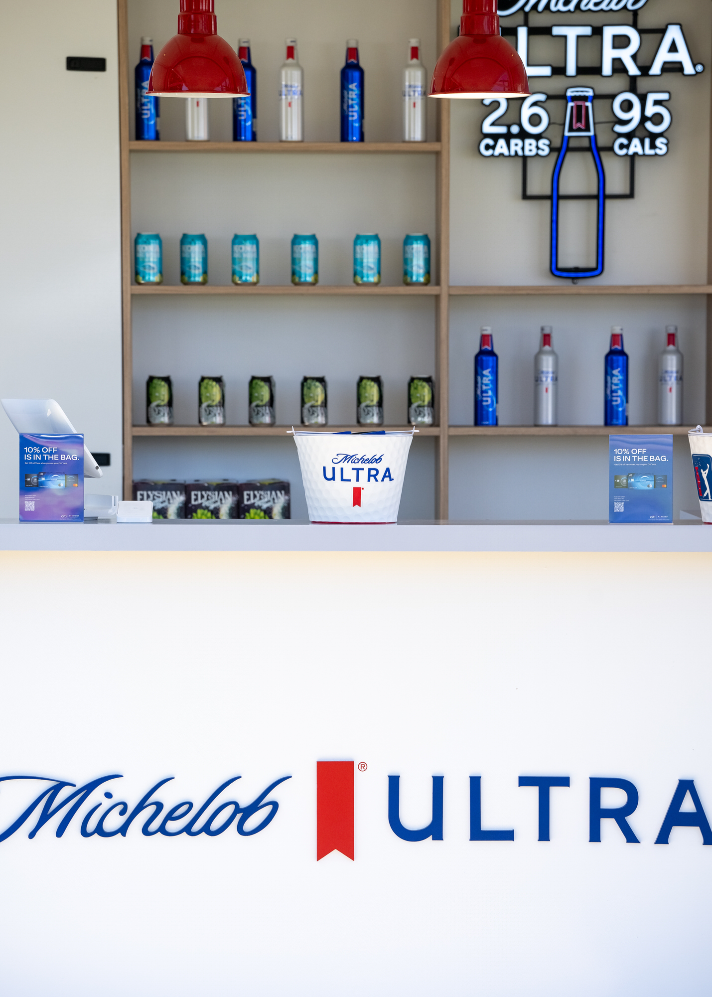 Sponsor bar stocked with bottles and cans behind a branded counter