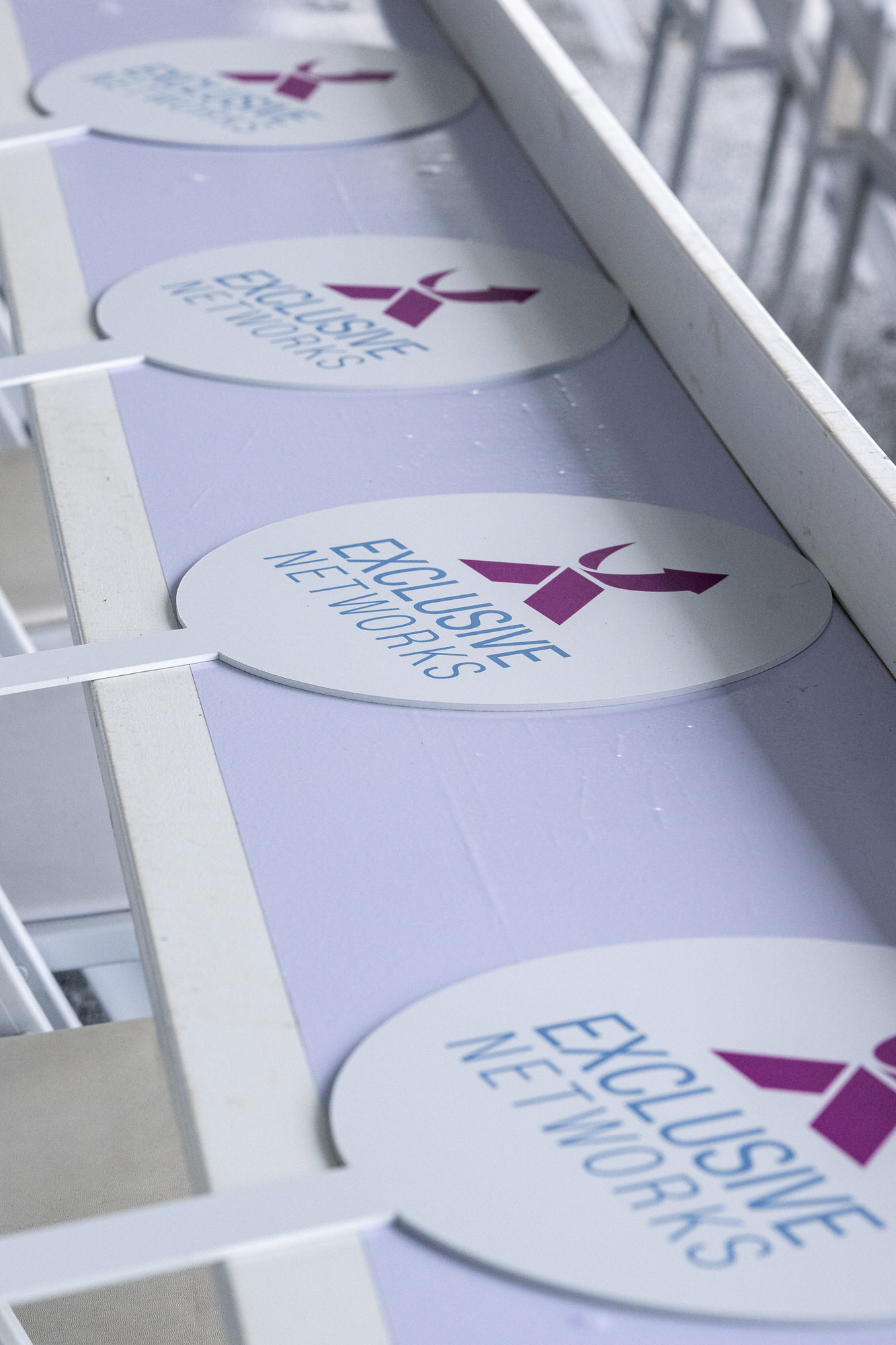 Branded coasters lined up along a white rail