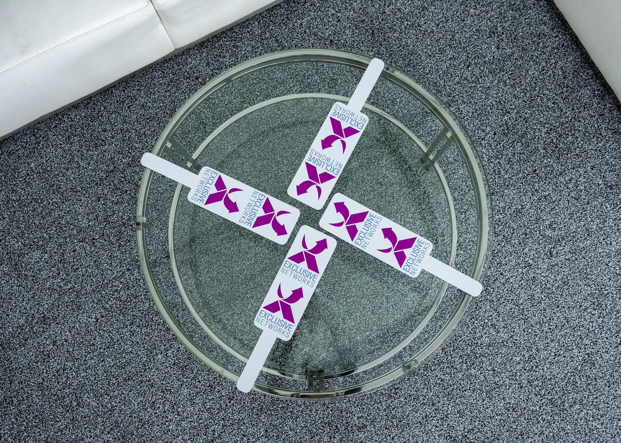 Overhead view of branded coasters arranged on a glass table