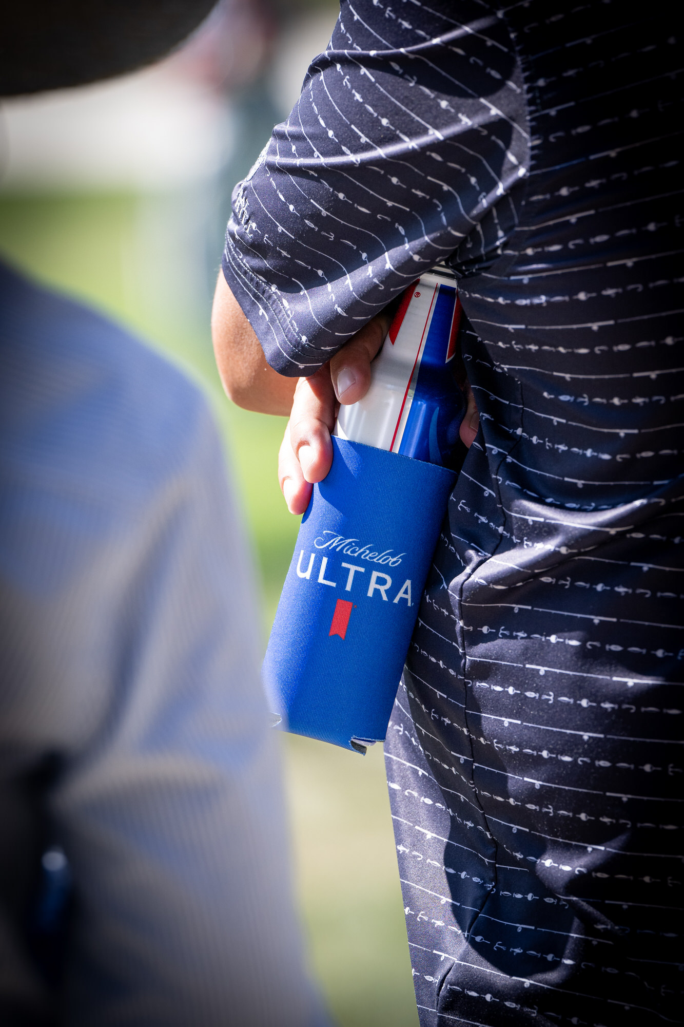 Guest holding a can in a branded sleeve