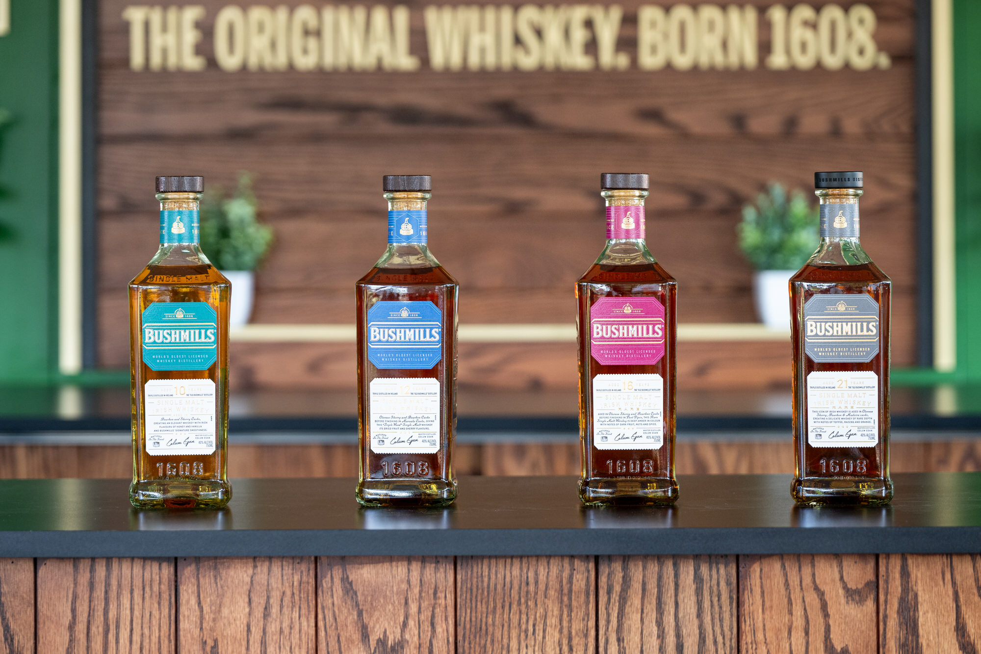 Four whiskey bottles lined up on a sponsor bar