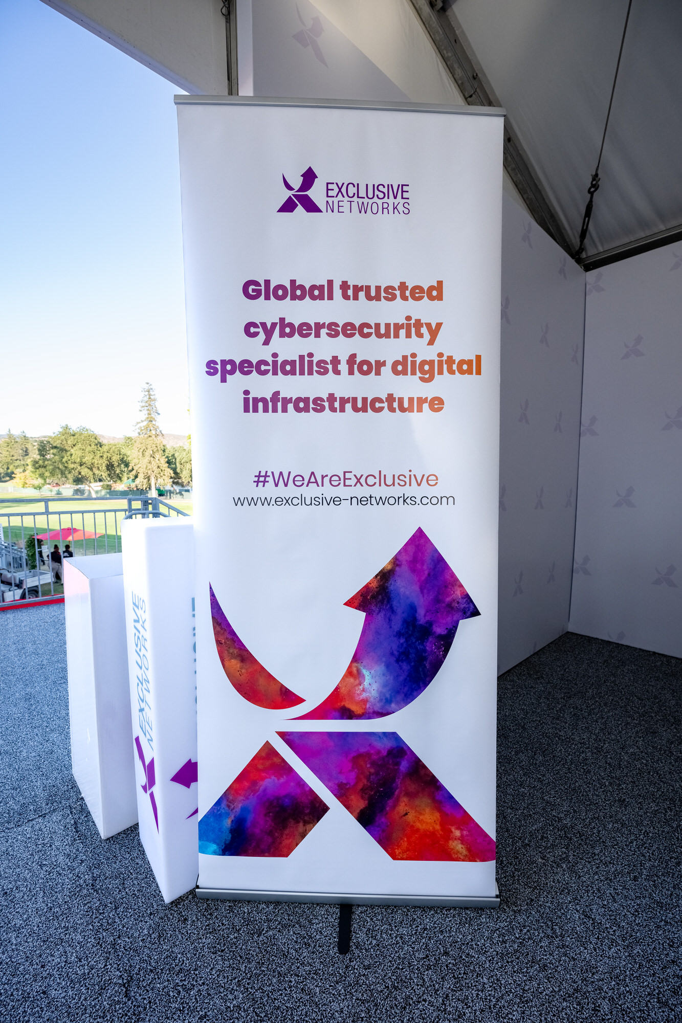 Sponsor banner standing inside a hospitality tent beside the course