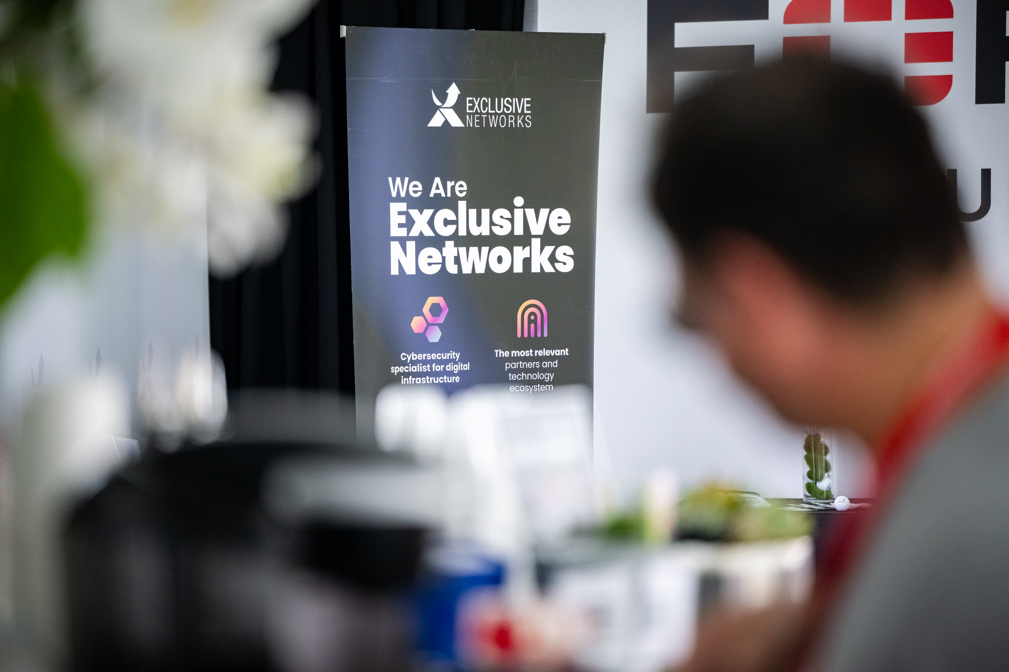 Sponsor banner behind a guest at a hospitality bar