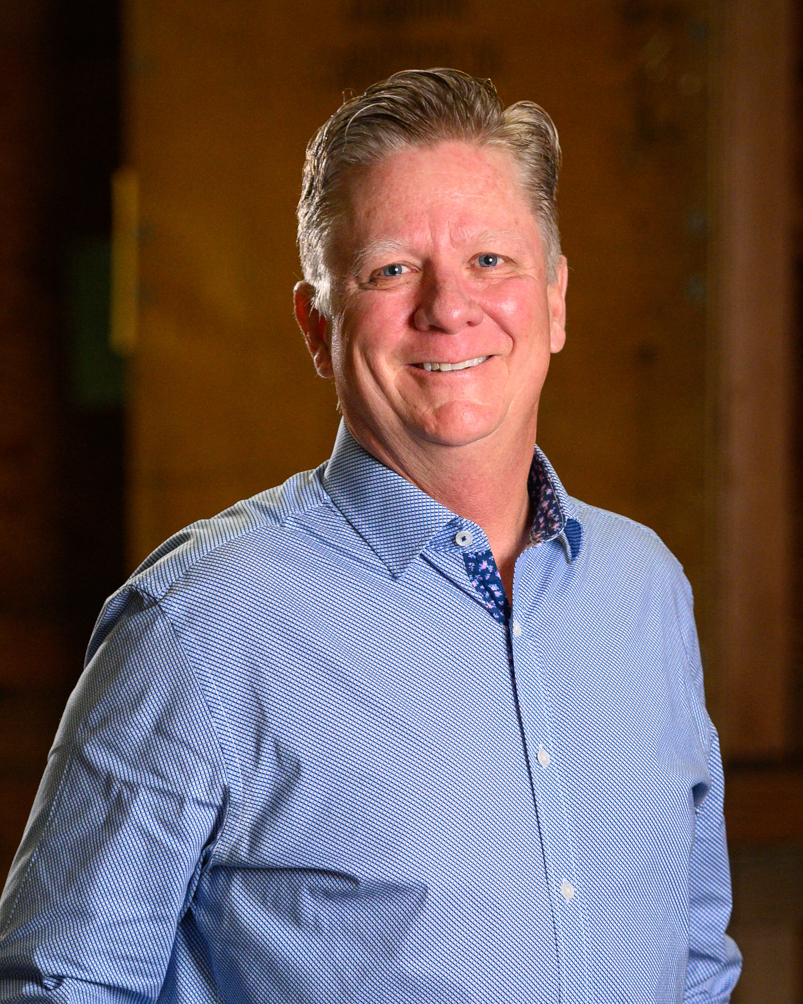 Portrait of a smiling man in a blue patterned shirt